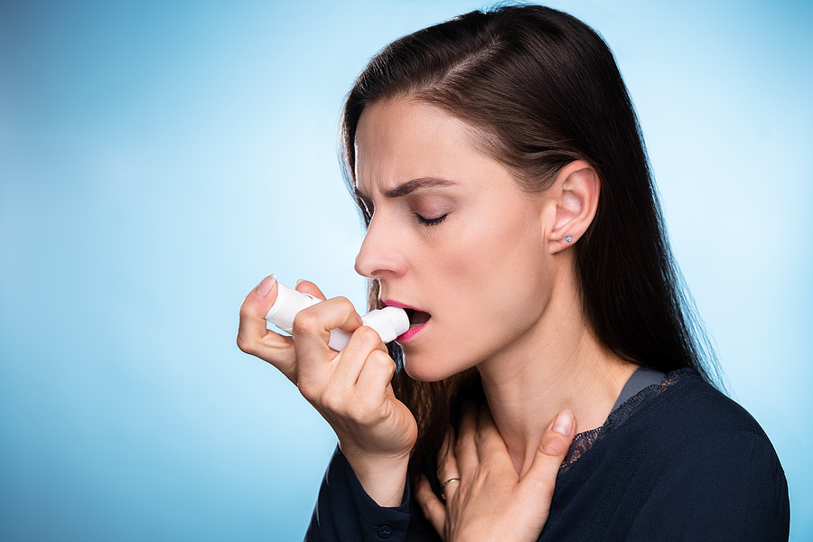 Woman With Asthma Using An Asthma Inhaler For Preventing Attacks