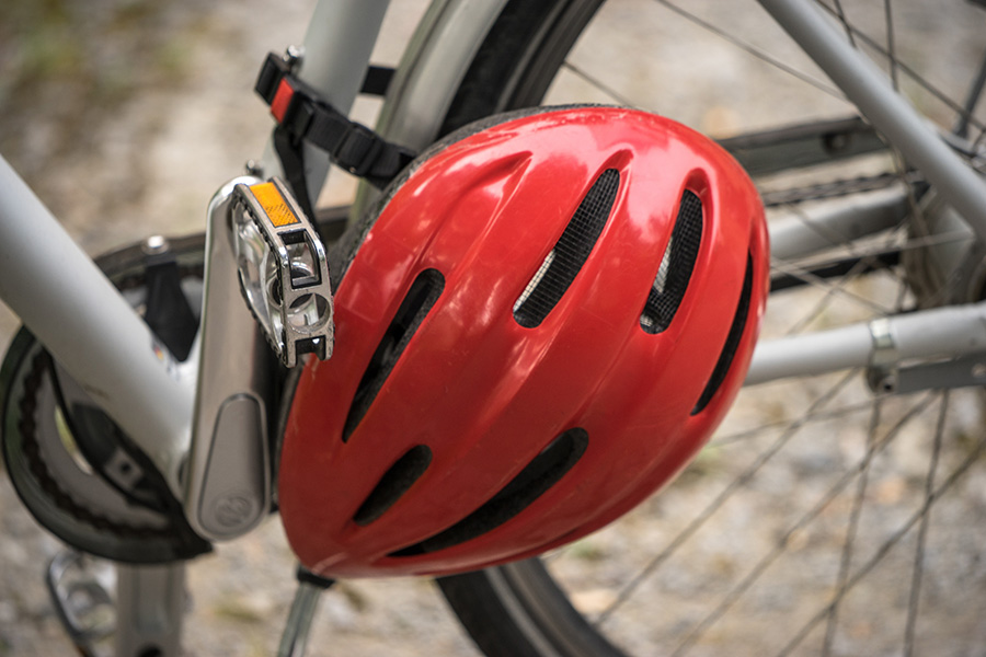 close-up of red bike helmet hanging on a parked bicycle